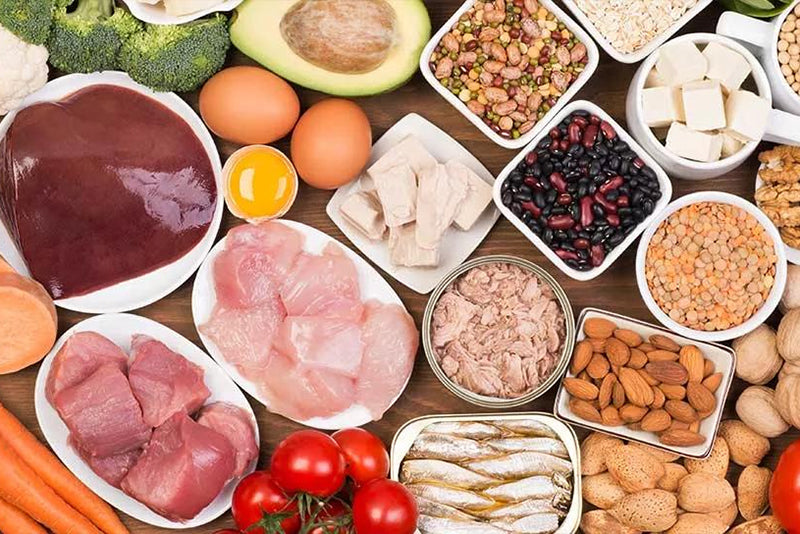 Plates of a bunch of different types of meats, beans, fruits and nuts.